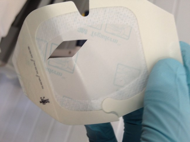 Create a window in a piece of tegaderm (still on paper backing) using fine scissors.